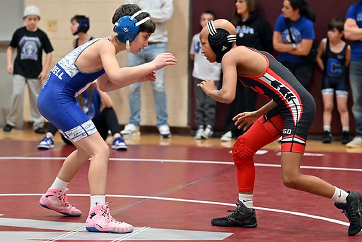 Two girls squaring up at the start of a wrestling match.